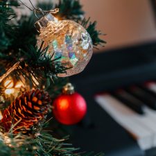 Zweige eines geschmückten Weihnachtsbaums auf dem Hintergrund von Klaviertasten.